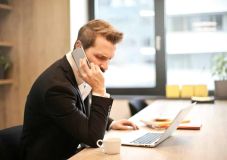 Man Having a Phone Call In-front of a Laptop